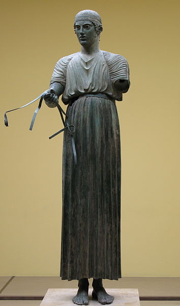 Woźnica z Delf jest ubrany w chiton. posąg pochodzi z V w p.n.e. Źródło