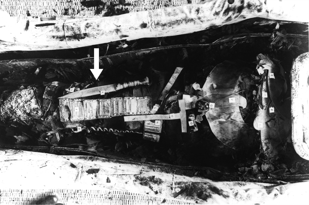 Mumii Tutanchamona. Żelazny sztylet (34,2 cm długości) znajduje się na prawym udzie (strzałka). Copyright Griffith Institute, University of Oxford.